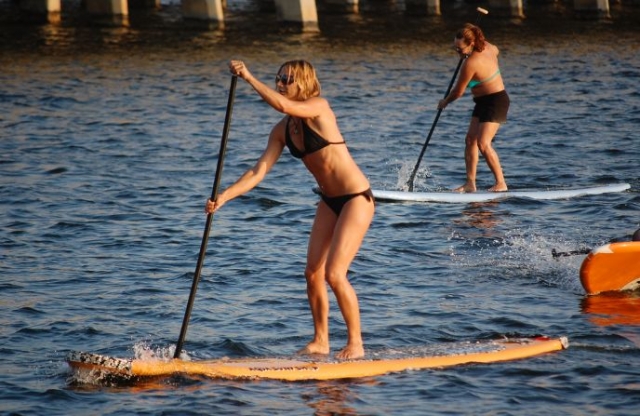 dos mujeres practicando sup en el mar